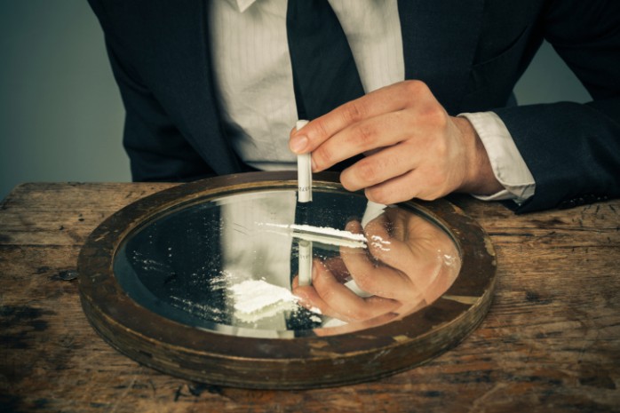 young_businessman_snorting_cocaine_off_of_mirror